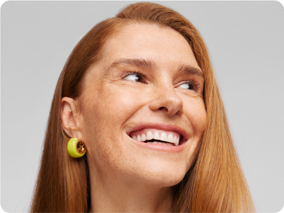 Radosna kobieta z rudymi włosami i piegami – naturalne piękno i zdrowie wspierane suplementacją nikalab.