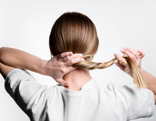 Kobieta trzymająca w rękach olejek do olejowania włosów