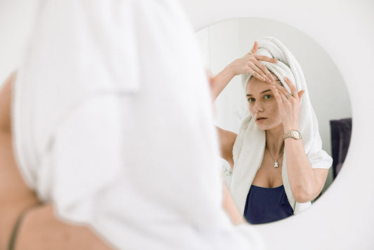 Kobieta wykonująca masaż twarzy by opóźnić pojawienie się zmarszczek. 