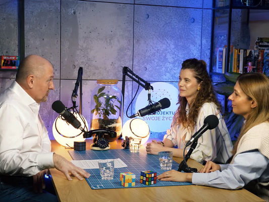 Założycielki nikalab podczas rozmowy w podcaście Zaprojektuj Swoje Życie – siedzą przy stole naprzeciwko prowadzącego, w otoczeniu mikrofonów, szklanek z wodą i kostek Rubika, w tle logo programu.