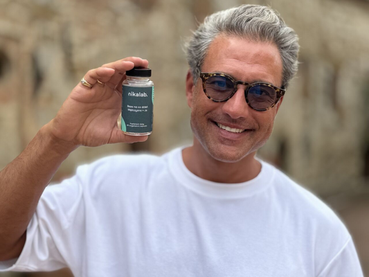 Piotr Czaykowski uśmiecha się i trzyma suplement diety nikalab. Zdjęcie jest okładką do artykułu „Moją bazą są bliskie relacje. Musiałem się tego nauczyć”