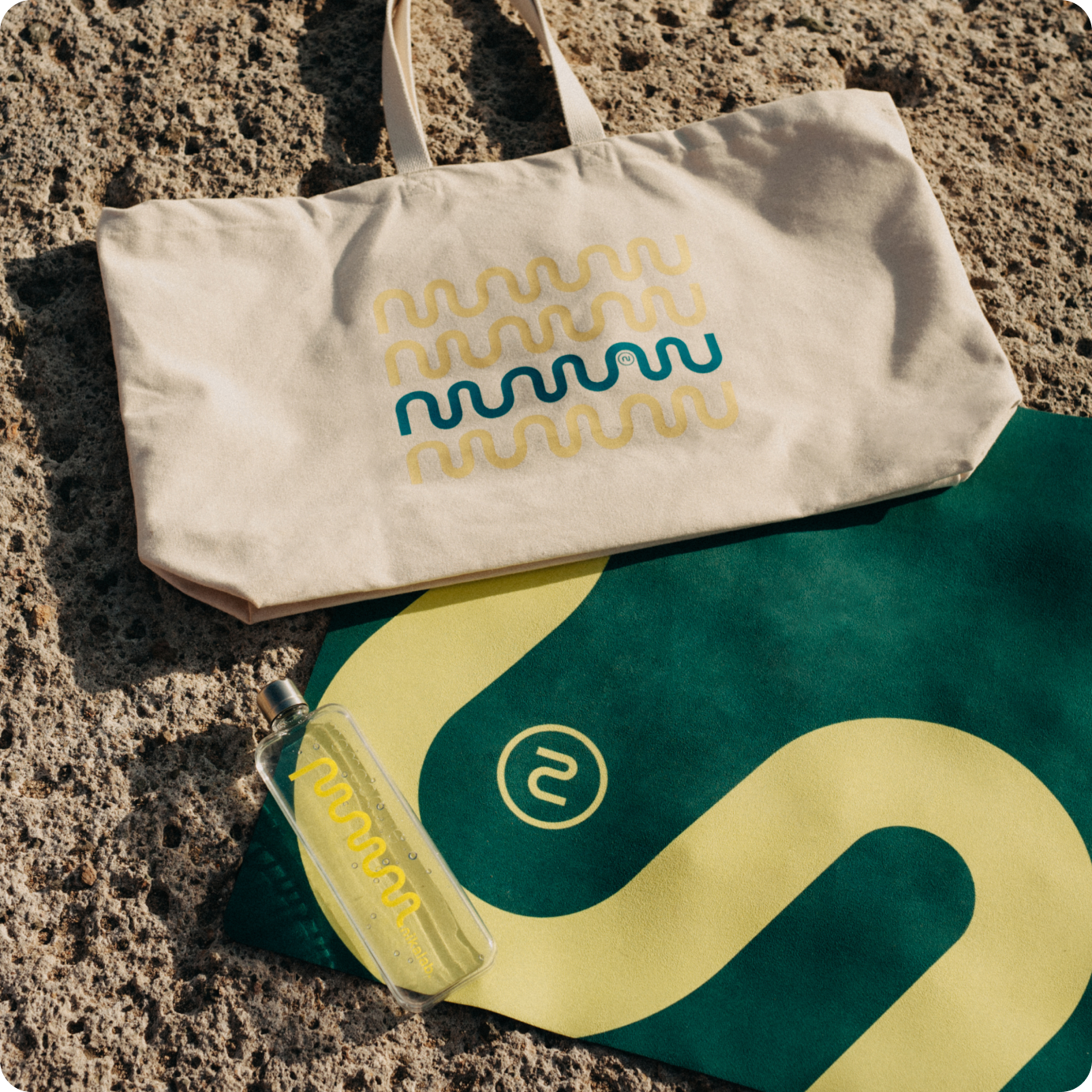 Zestaw nikalab limited edition: beżowa torba bawełniana z kolorowym nadrukiem, butelka memobottle™ z żółtym logo i zielono-żółta mata do jogi – idealny komplet na lato w rytmie mindful.