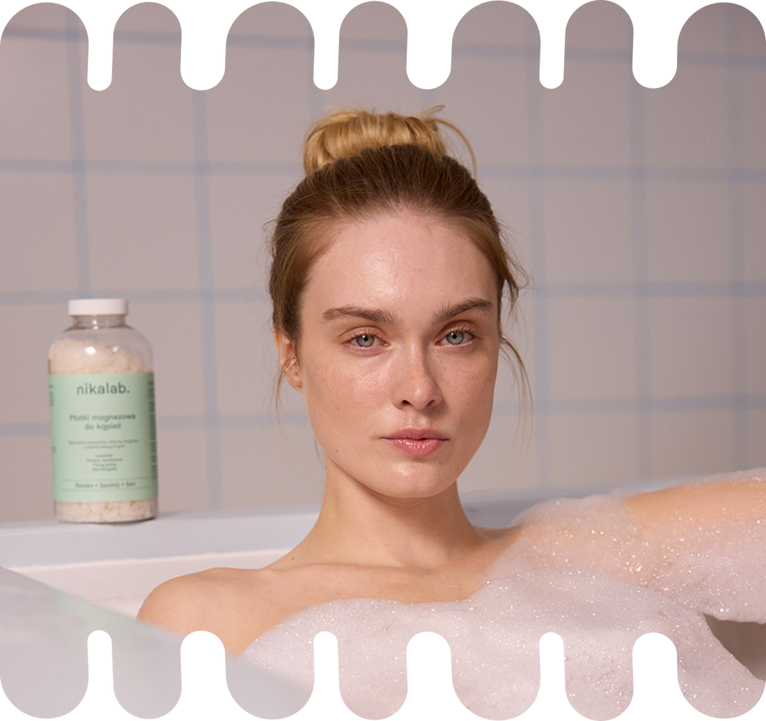 Kobieta relaksująca się w wannie z pianą, w tle widoczne opakowanie płatków magnezowych do kąpieli RELAKS od nikalab oraz grafika z informacją o efektach relaksu, snu i nawilżenia skóry.