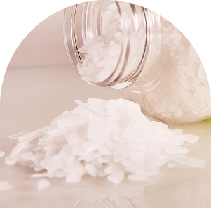 Zbliżenie na kryształki płatków magnezowych wysypane z opakowania płatków magnezowych do kąpieli RELAKS od nikalab.