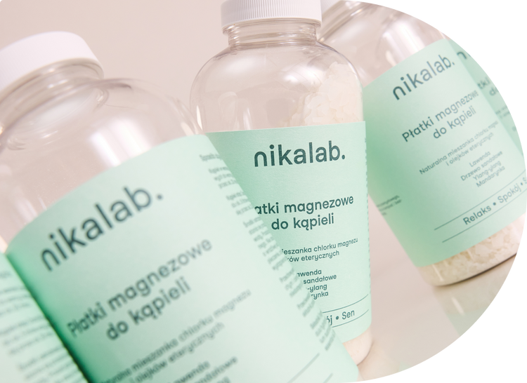 Opakowania płatków magnezowych do kąpieli RELAKS od nikalab na jasnym tle, z widoczną etykietą produktu i kryształkami soli magnezowej w środku.