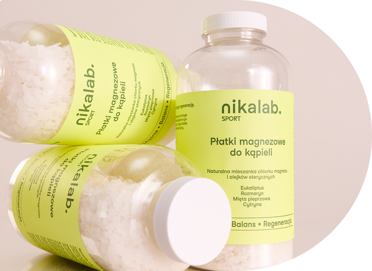 Opakowania płatków magnezowych do kąpieli SPORT od nikalab na jasnym tle, z widoczną etykietą produktu i kryształkami soli magnezowej w środku.