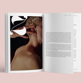 Rozkładówka książki „Sex & Cook. Miłość od kuchni” dostępnej w nikalab – po lewej stronie fotografia nagiego mężczyzny z krótkimi blond włosami, którego ucha dotyka dłoń, po prawej tekst rozdziału „Seks i zmysły”.