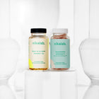 Zestaw dwóch suplementów diety nikalab: Baza na co dzień dla kobiet 18–49 lat (60 wegańskich kapsułek) i Liposomalna witamina C (60 wegańskich kapsułek) – oba w biodegradowalnych słoiczkach z jasnymi etykietami.