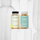 Zestaw dwóch suplementów diety nikalab: Baza na co dzień dla kobiet 18–49 lat (60 wegańskich kapsułek) i Kurkumina + Piperyna (60 wegańskich kapsułek) – oba w biodegradowalnych słoiczkach z jasnymi etykietami.