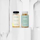 Zestaw dwóch suplementów diety nikalab: Baza na co dzień dla kobiet 50+ lat (60 wegańskich kapsułek) i Kurkumina + Piperyna (60 wegańskich kapsułek) – oba w biodegradowalnych słoiczkach z jasnymi etykietami.